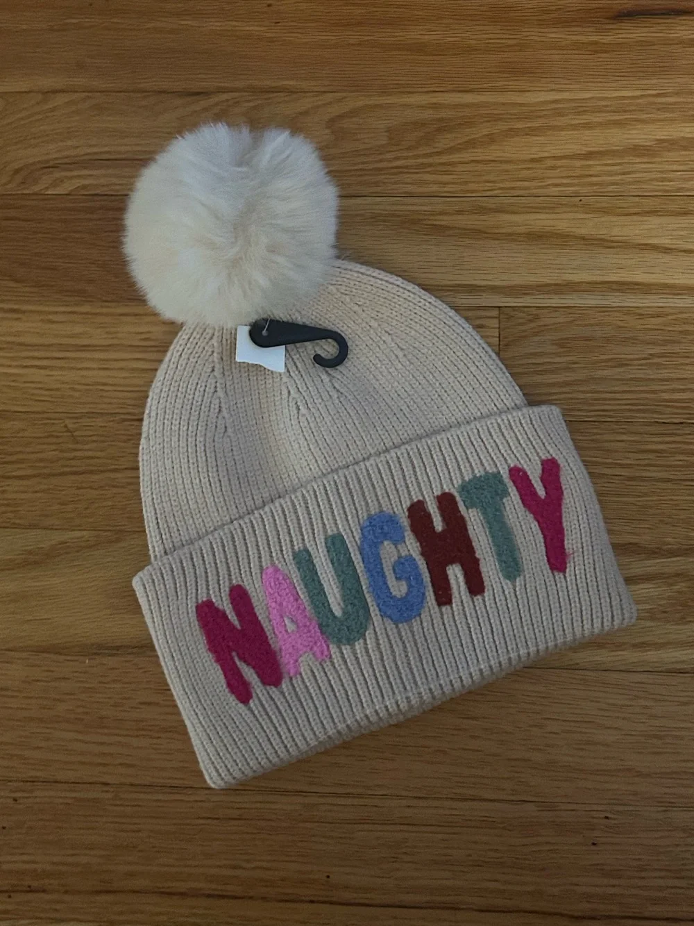 Beige Pom Pom Beanie with 'NAUGHTY' Multicolor Letters